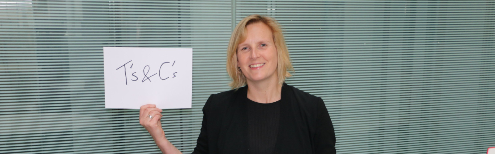 Emily holding sign saying Terms and Conditions